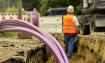 Un employé d'une société de BTP travaille sur un chantier de raccordement pour lequel la route a dû être coupée