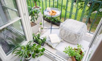 joli balcon avec coussins d'extérieur, plantes et guirlandes