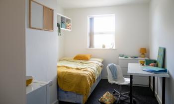 Petite chambre coquette pour un étudiant, avec un coin nuit, un coin bureau et un lavabo