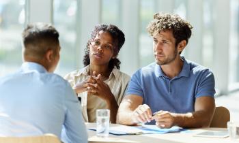 Un couple écoute avec attention les explications d'un conseiller bancaire au cours d'un rendez-vous