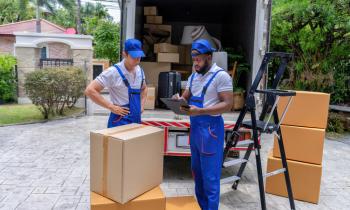Entreprise de déménagement avec deux hommes devant leur camion. 