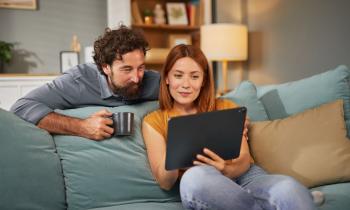 couple regarde la tablette dans le canapé