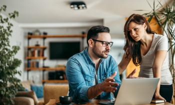 couple inquiet devant ordinateur se demande s'il doit faire remplacer son toit qui contient de l'amiante
