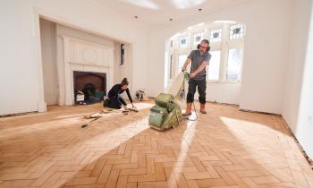 couple en train de rénover le parquet du salon
