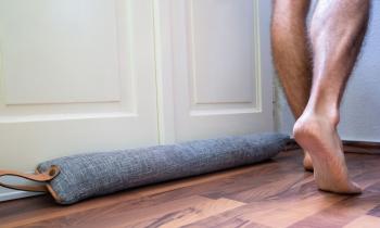 En obstruant la zone de contact entre le bas de la porte et le sol, le boudin de porte limite les échanges d’air, réduit les courants d’air et peut freiner sensiblement les pertes énergétiques. © AndreyPopov - Getty images