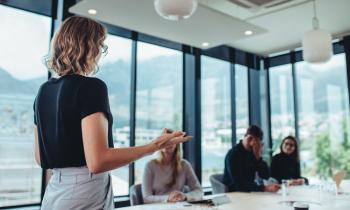 Femme au bureau, animant une réunion avec ses collègues. 