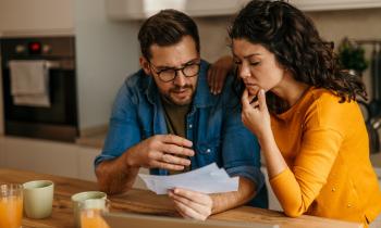 Un couple découvre inquiet le contenu d'un courrier recommandé dans sa cuisine