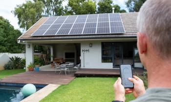 Un homme utilise une application mobile pour contrôler son système d’énergie solaire