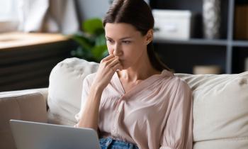 jeune femme assise sur son canapé se renseigne sur la possibilité de faire plusieurs offres d'achat sur un même bien 