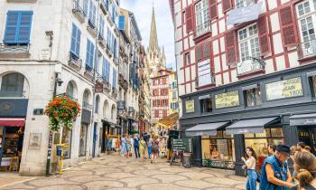 Touristes marchant dans une rue commerçante du centre de Bayonne, France