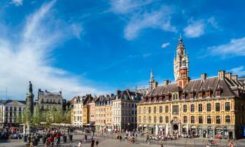 vue sur une place de Lille avec piétons et cyclistes