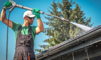Homme nettoie la toiture sans monter sur le toit