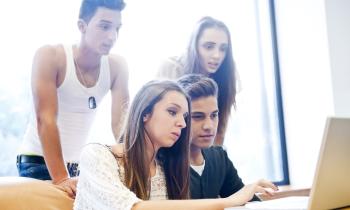 Un groupe de 4 étudiants effectue une recherche sur un ordinateur