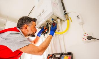 Un technicien assure la réparation d'une chaudière à gaz dans un logement