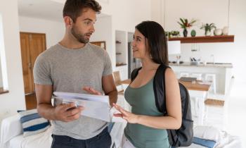 Un jeune homme et une étudiante échangent autour du règlement intérieur de la colocation