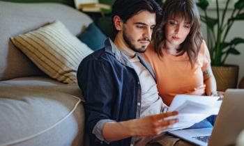Couple comparant des offres d'assurance emprunteur en ligne.