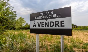 Panneau de vente d'un terrain constructible.