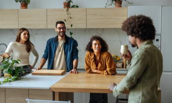 Colocataires en discussion dans la cuisine couleur bois clair et blanc