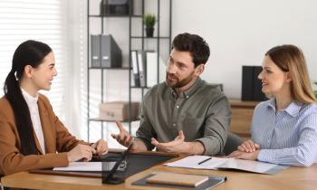 Couple signe l'acte de vente chez le notaire.