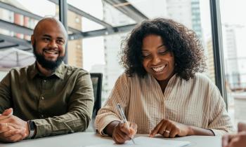 Couple signant un contrat de vente.