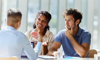 Un couple échange avec son banquier au cours d'un rendez-vous