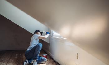Homme peignant les murs d'un appartement.