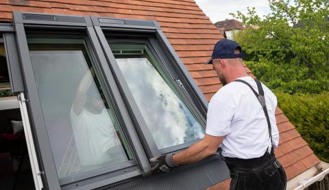 Ouvrier en train d'installer fenêtre de toit