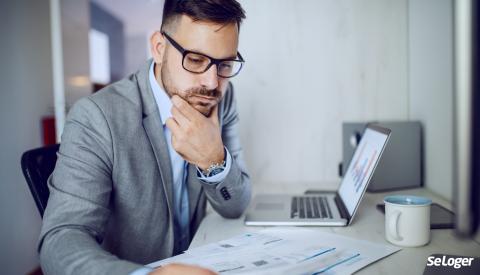 Un homme qui regarde les documents d'une SCI