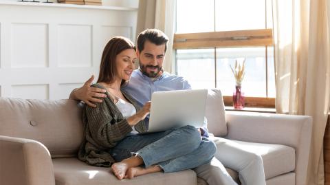 Un couple devant un ordinateur portable