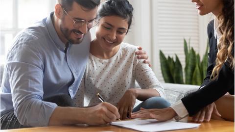 Un couple signe un acte de vente