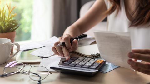 Une femme calcule si son salaire couvre trois mensualités de loyers