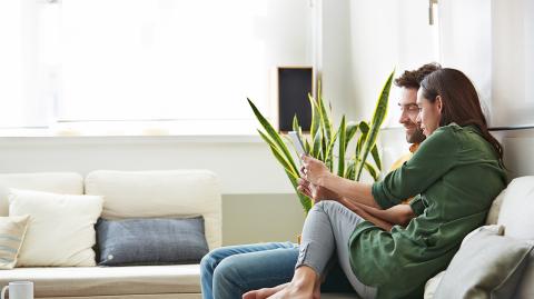 Un couple devant une tablette tactile