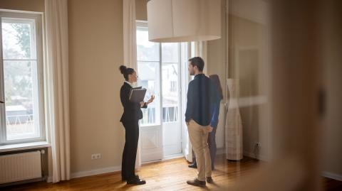 Une jeune femme avec un couple visitent une maison