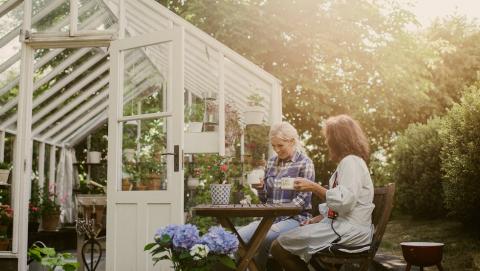 deux femmes assises à une table dans le jardin