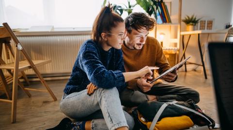 Un jeune couple en train de regarder une tablette 