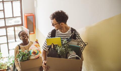 Jeunes avec des cartons dans les mains dans un escalier