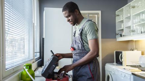 plombier en train de travailler dans cuisine