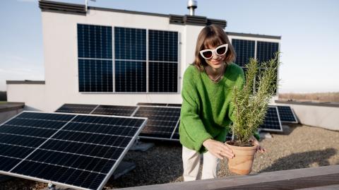 femme sur son toit entourée de panneaux photovoltaïques