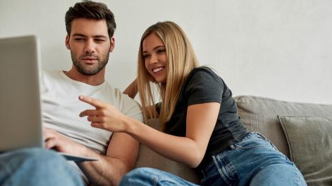 Jeune couple en train de regarder un ordinateur