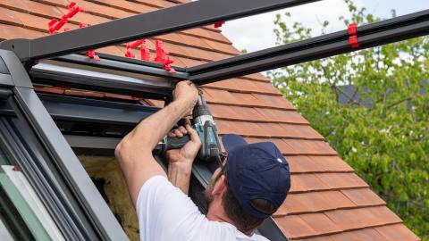 ouvrier en train d'installer des fenêtres de toit