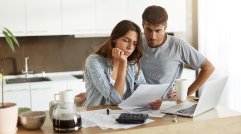 couple en train de regarder des papiers dans leur cuisine