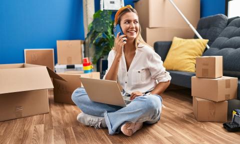 Jeune femme dans son salon entourée de cartons