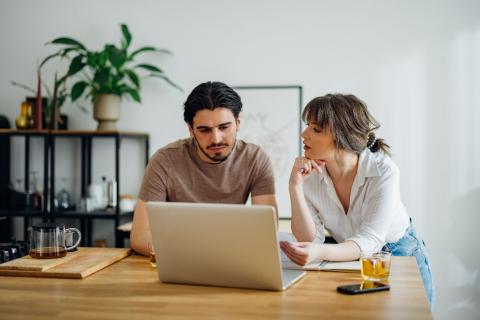 Couple s'interroge quant à l'amélioration de leur DPE devant leur ordinateur