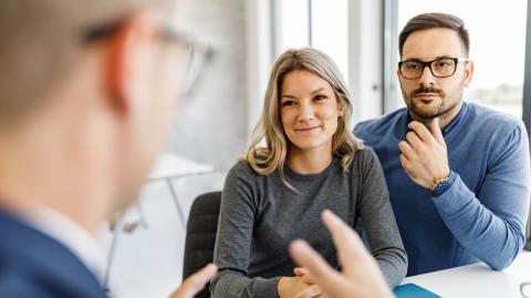 Un couple échange avec son banquier, assis devant un bureau