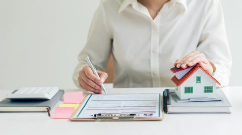 Une femme étudie un document lié aux diagnostics immobiliers d'un logement