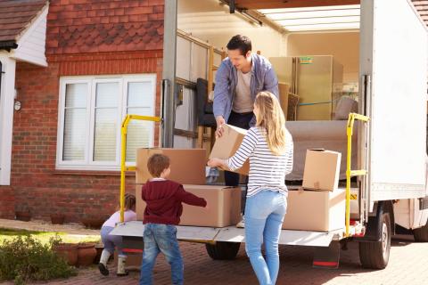 Famille déchargeant leur camion devant leur nouveau logement