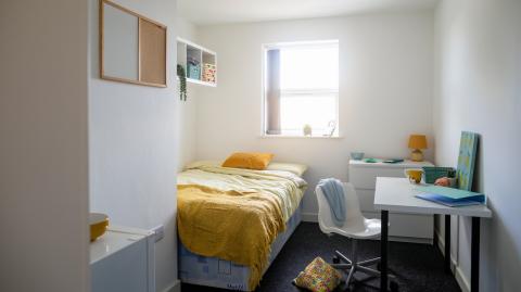 Petite chambre coquette pour un étudiant, avec un coin nuit, un coin bureau et un lavabo