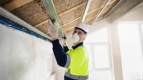 Un artisan procède à l'isolation de la toiture d'une maison
