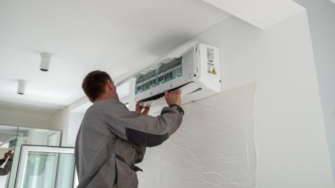 Professionnel qui installe une climatisation