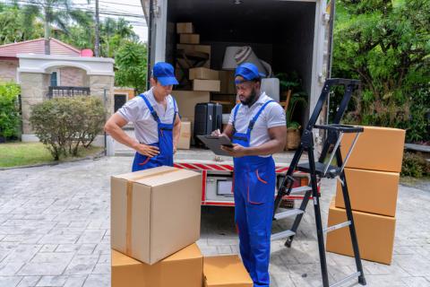 Entreprise de déménagement avec deux hommes devant leur camion. 
